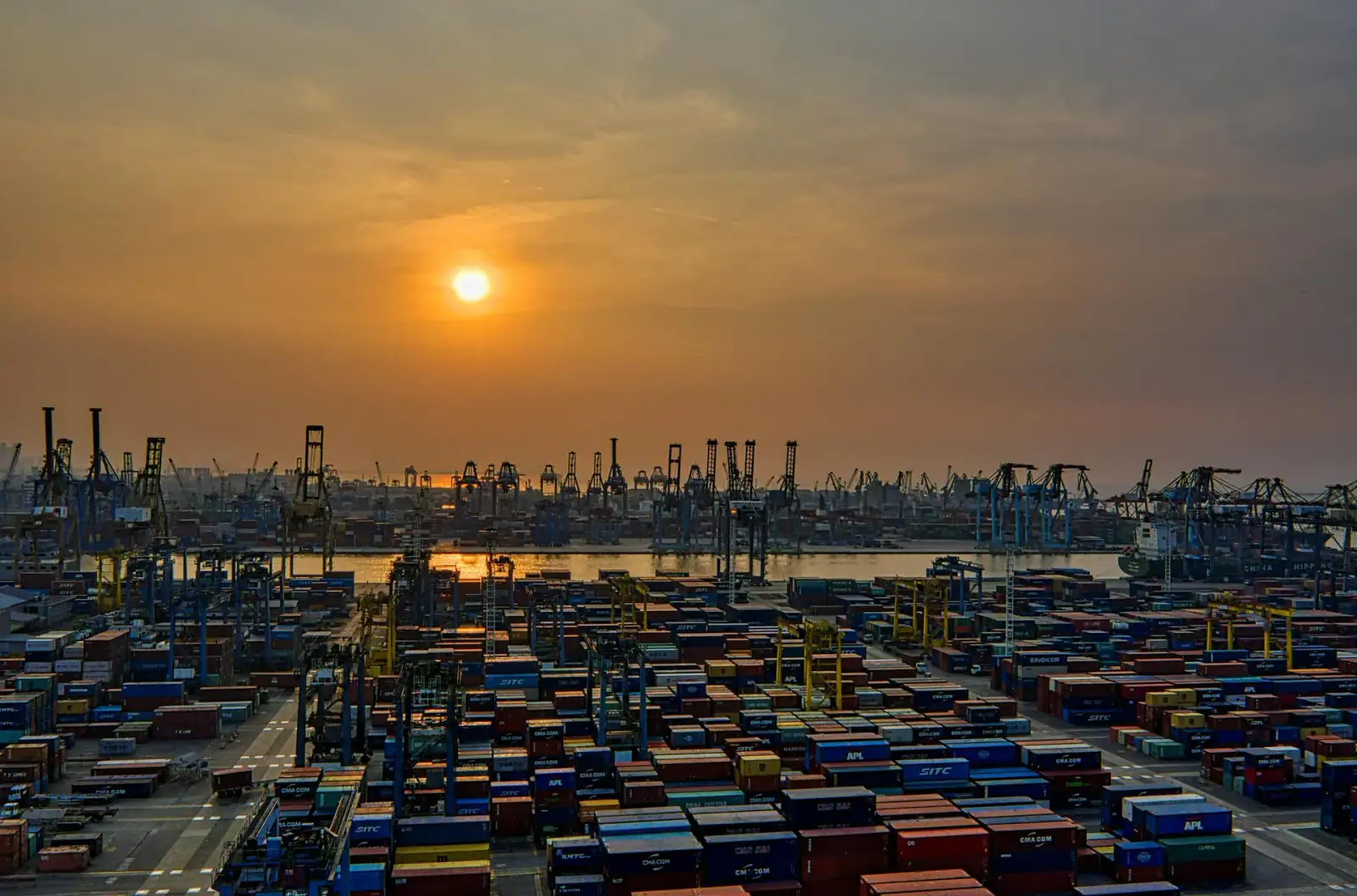 Intermodal freight containers staged at a port terminal at dusk